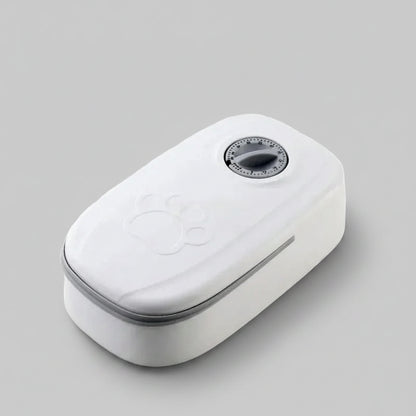 A white automatic pet feeder with a digital timer dial on top and an embossed paw print, shown on a plain white background.
