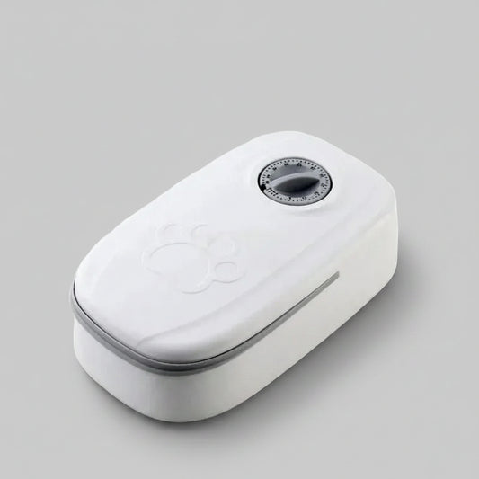 A white automatic pet feeder with a digital timer dial on top and an embossed paw print, shown on a plain white background.